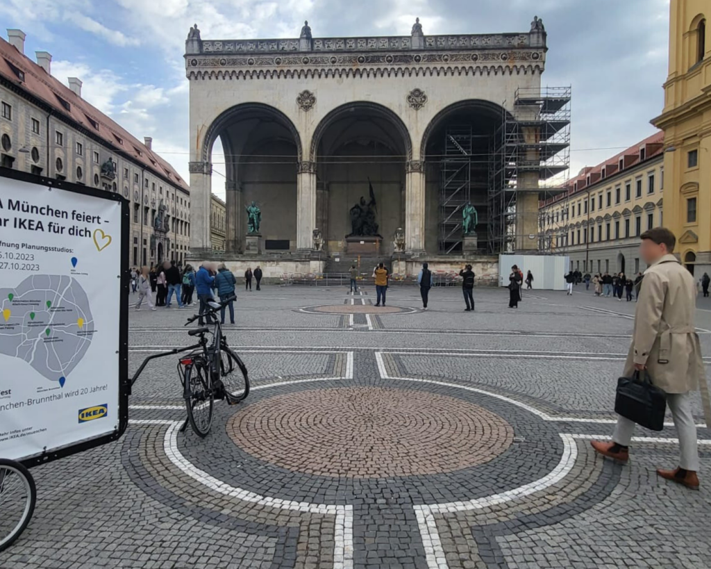 Vorbeilaufende Passanten lesen sich die Werbebotschaft auf unseren Werbefahrrädern durch 