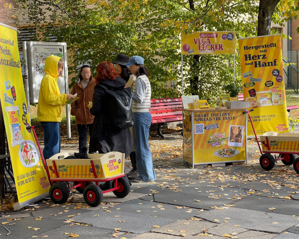 Rücker dairy stand concept with roll-ups, branded handcarts, promoter outfits and a branded counter